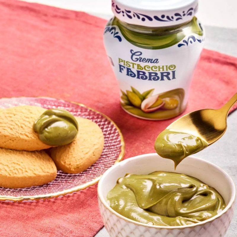 Jogurt z kremem pistacjowym Fabbri Crema Pistacchio. Obok opakowanie kremu i kruche ciasteczka.